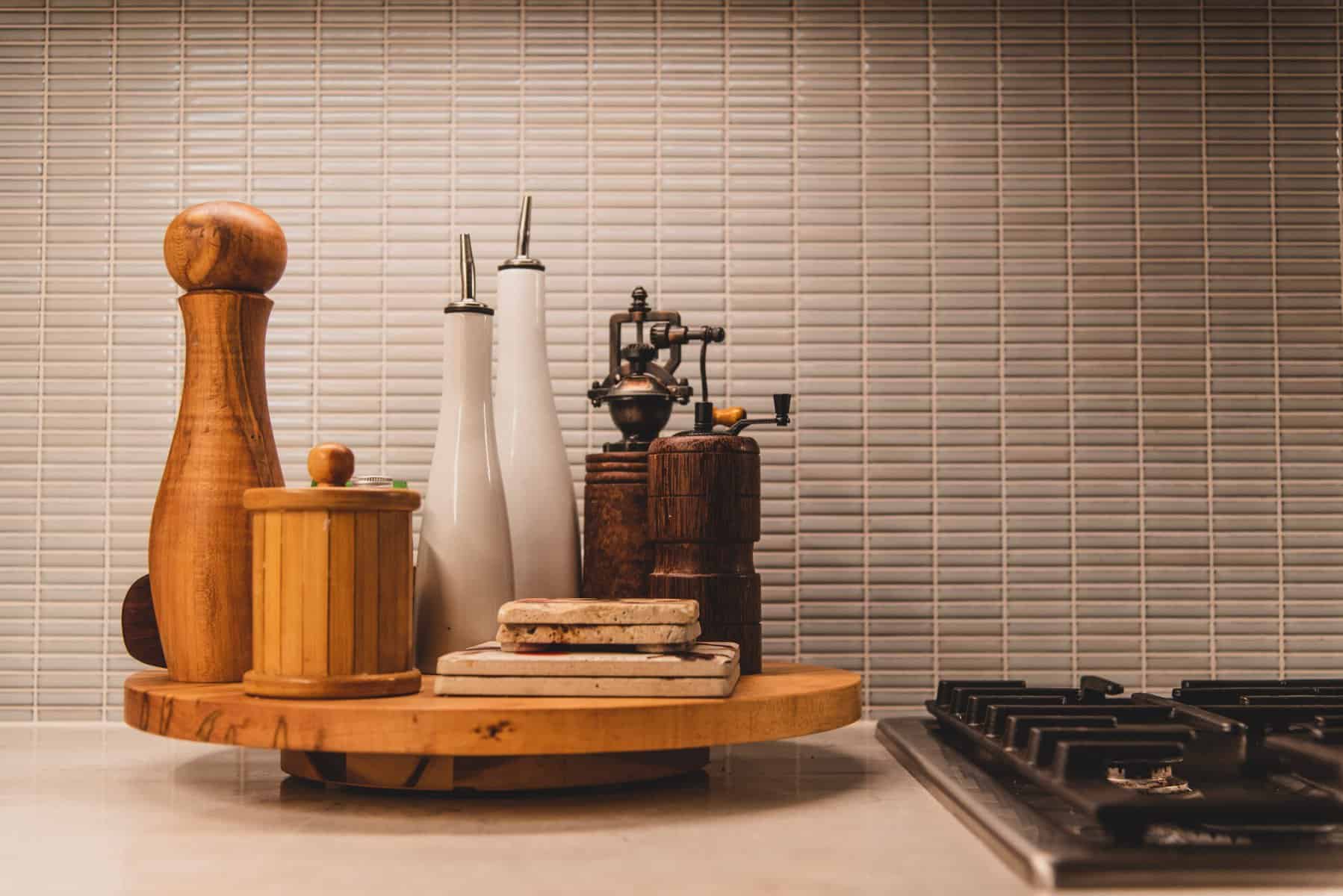 Salt, Pepper, healthy fats, and oils placed on a lazy susan next to a stove in a kitchen